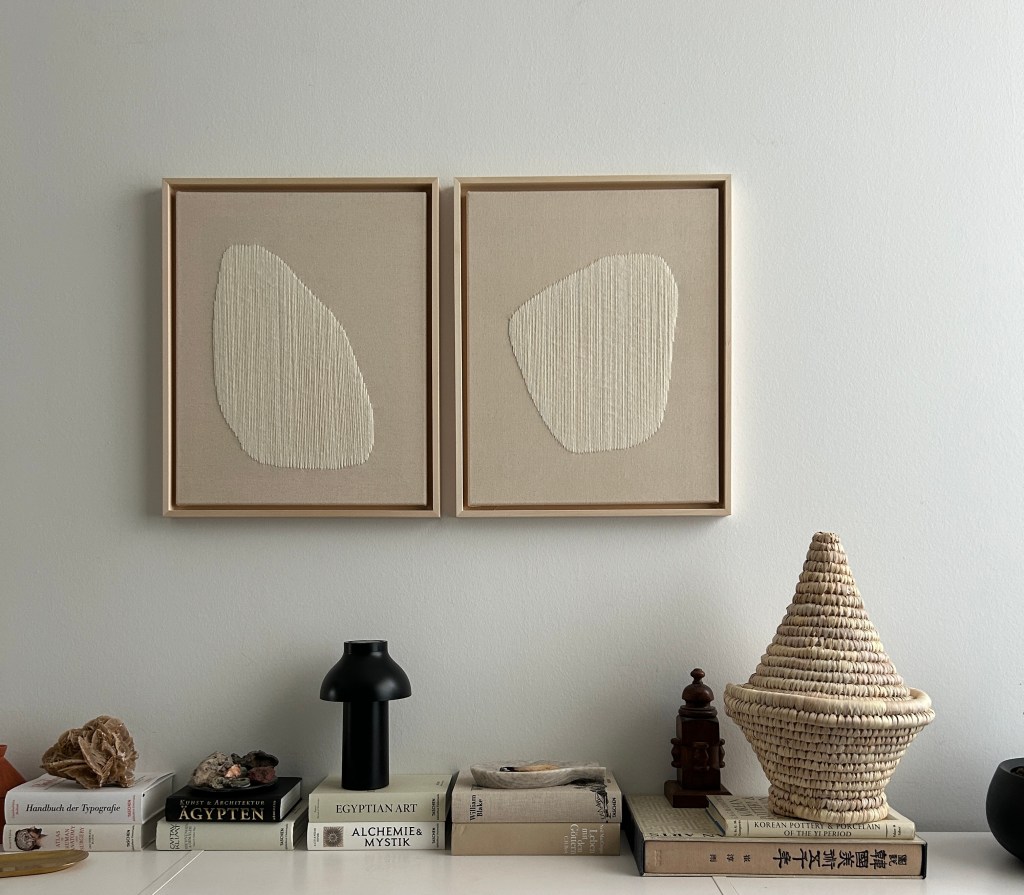Zwei textile Kunstwerke aus der Raindrop-Serie von Silvija Kicivoj an einer Wand, fotografiert in einem wohnlichen Interieur.